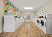 Thumbnail 5 of 22 - Laundry room with washers and dryers and a mural on the wall.