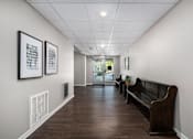 Thumbnail 29 of 40 - a long hallway with a couch and some pictures on the wall