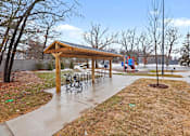 Thumbnail 25 of 31 - A wooden shelter with bicycle racks is situated in a park.