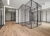 Thumbnail 4 of 22 - A room with wooden floors and a large black wireframe cube structure.