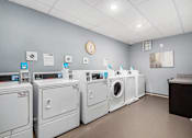 Thumbnail 36 of 40 - a laundromat with a row of washers and dryers and a clock