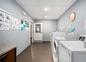 Thumbnail 33 of 40 - a laundry room with washing machines and a clock on the wall