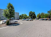 Thumbnail 31 of 40 - a parking lot with cars in front of an apartment building