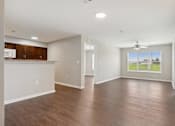 Thumbnail 4 of 38 - an empty living room and kitchen with wood flooring