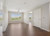 Thumbnail 3 of 38 - an empty living room with a ceiling fan and a window