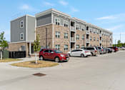 Thumbnail 1 of 12 - a building with a parking lot in front of it
