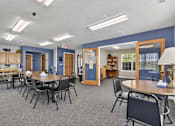 Thumbnail 6 of 49 - A room with tables and chairs and a blue wall.