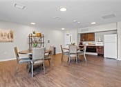 Thumbnail 13 of 38 - a dining area with a table and chairs and a kitchen in the background