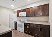 Thumbnail 7 of 38 - a kitchen with dark cabinets and white appliances and a refrigerator