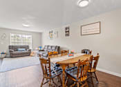 Thumbnail 6 of 12 - a dining area with a table and chairs and a couch in the background