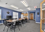 Thumbnail 3 of 49 - A conference room with a long table and chairs, a television, and a star decoration on the wall.