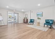 Thumbnail 6 of 35 - a living room with two blue chairs in front of a door