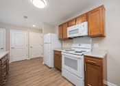 Thumbnail 15 of 58 - A kitchen with a white stove and a white microwave above it.