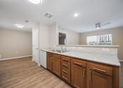 Thumbnail 16 of 58 - A kitchen with wooden floors and white appliances.
