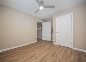 Thumbnail 28 of 58 - A room with a ceiling fan and wooden flooring.
