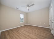 Thumbnail 27 of 58 - A room with a ceiling fan and wooden flooring.