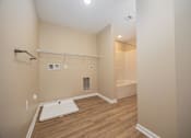 Thumbnail 26 of 58 - A bathroom with a white sink and wooden floor.