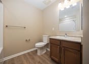 Thumbnail 25 of 58 - A bathroom with a toilet, sink, and a mirror.