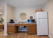 Thumbnail 41 of 58 - A kitchen with a white refrigerator and a round mirror on the wall.