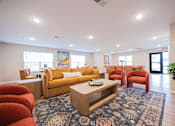 Thumbnail 33 of 58 - A living room with a yellow couch and red chairs.