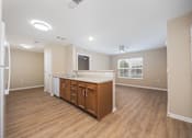 Thumbnail 11 of 58 - A kitchen with wooden floors and white appliances.