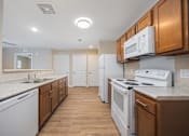 Thumbnail 8 of 58 - A kitchen with white appliances and wooden cabinets.
