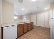 Thumbnail 17 of 58 - A kitchen with a white dishwasher and wooden cabinets.