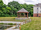 Thumbnail 45 of 56 - A gazebo is situated in a grassy area in front of a house.