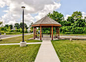 Thumbnail 46 of 56 - A gazebo is surrounded by a grassy area and a concrete walkway.