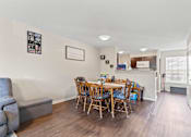 Thumbnail 8 of 12 - a dining area with a table and chairs and a kitchen in the background