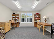 Thumbnail 9 of 49 - A room with a desk, chairs, and bookshelves.