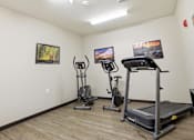 Thumbnail 15 of 66 - A room with a treadmill, elliptical trainer and a stationary bike.