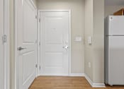 Thumbnail 11 of 39 - a hallway with white doors and a refrigerator