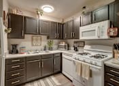 Thumbnail 30 of 30 - A kitchen with a white stove and black cabinets.