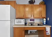 Thumbnail 22 of 49 - A kitchen with wooden cabinets and a white refrigerator.