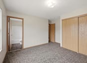 Thumbnail 12 of 43 - A room with a carpeted floor and a wooden door.