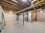 Thumbnail 24 of 43 - A room under construction with exposed pipes and wooden beams.
