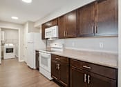 Thumbnail 6 of 38 - a kitchen with white appliances and wooden cabinets