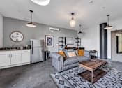 Thumbnail 19 of 51 - a living area with a couch coffee table and a refrigerator