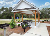 Thumbnail 25 of 50 - a picnic shelter with benches and a barbecue grill