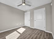 Thumbnail 13 of 18 - A room with a ceiling fan and two doors.