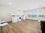 Thumbnail 10 of 35 - a laundry room with washer and dryers and a table with chairs