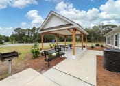 Thumbnail 26 of 50 - a picnic pavilion with benches and a grill