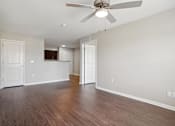 Thumbnail 31 of 38 - an empty living room with wood floors and a ceiling fan
