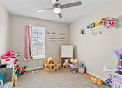 Thumbnail 9 of 12 - a bedroom with a ceiling fan and toys on the floor
