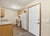 Thumbnail 24 of 66 - A kitchen with a white refrigerator and wooden cabinets.