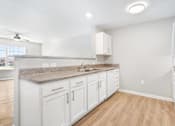 Thumbnail 10 of 26 - a kitchen with white cabinets and a counter top