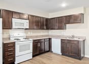 Thumbnail 11 of 35 - a kitchen with white appliances and brown cabinets