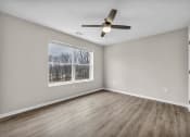 Thumbnail 32 of 51 - an empty living room with a window and a ceiling fan