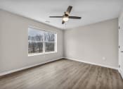 Thumbnail 21 of 51 - an empty living room with a window and a ceiling fan